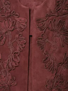 Close-up detail of burgundy suede embroidered vest, showcasing intricate floral applique texture.