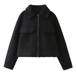 Detail view of stylish black wool lapel jacket with front zipper and chest pockets.
