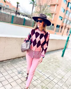 Gedetailleerd overzicht van het stijlvolle roze argyle gebreide vest voor dames.