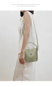 Vue détaillée du sac seau tissé élégant, avec une texture en cuir premium et un fermoir en métal.