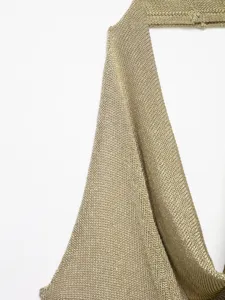 Close-up of metallic knit fabric, shimmering gold halter camisole top detail view.