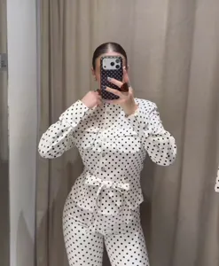 Women white black polka dot long sleeve button up top and pants matching outfit set.