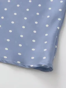 Blue polka dot satin skirt detail shot showing smooth fabric texture and exquisite hemline stitching.