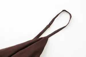 Brown camisole top shoulder strap detail, adjustable thin strap, soft fabric texture close-up.