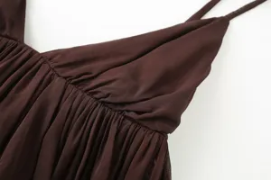 Close-up detail of brown pleated strap camisole top, showing delicate ruching texture and fabric.
