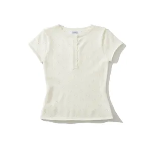 Detailed shot of the knitted short-sleeve top featuring button closure and breathable eyelet pattern.