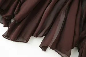 Close-up detail of brown sheer mesh ruffled hem, showing soft texture and fine stitching.