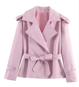 Detalle de gabardina corta rosa, cuello con solapa elegante, cinturón y puños con botones.