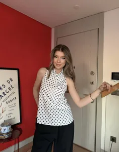 Vista detallada de un top halter con lunares de estilo retro llevado por una modelo.