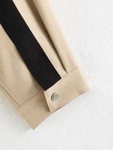 Close-up detail of the khaki jacket sleeve cuff with a contrasting black stripe and metal button.