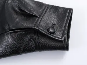 Close-up detail of the black faux leather jacket sleeve cuff with button and fine texture.