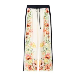 Close-up view of vintage floral print trousers with dark blue side stripes and drawstring waist.
