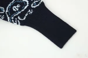 Detailed close-up view of a knitted cardigan sleeve featuring vintage blue and white jacquard pattern.