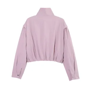 Detalle de la parte trasera de chaqueta corta rosa con dobladillo elástico y puños de botones.