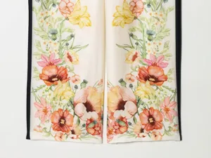 Floral print trousers detail close-up showing vibrant vintage botanical patterns and side stripes.