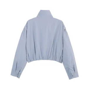 Detalle de la espalda de chaqueta corta con cuello alto azul claro, prenda casual de mujer.