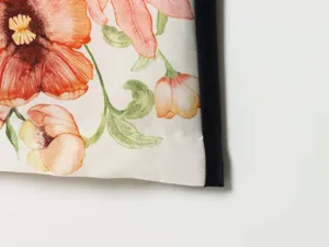 Detailed fabric close-up of vintage floral print apparel featuring contrast piping edge.