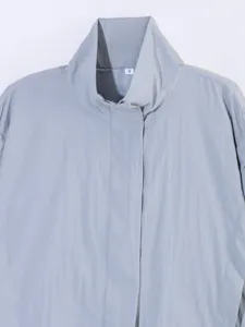 Primer plano del elegante cuello alzado y los detalles limpios de la cremallera de la chaqueta.