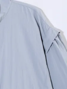 Primer plano detallado de chaqueta corta de mujer azul claro con cuello alzado, casual.