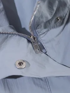 Primer plano detallado de la cremallera de la chaqueta casual y los botones de presión.