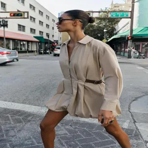 Dettaglio di strada all'aperto dell'elegante abito beige a maniche lunghe con risvolto.