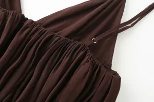 Close-up detail of brown camisole showing delicate spaghetti straps and pleated texture.