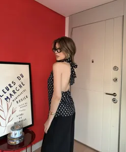 Vista detallada del top halter negro con lunares blancos para mujer y diseño de lazo en la espalda.
