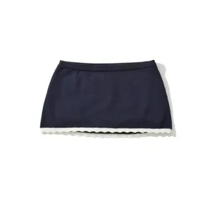 Navy blue knit mini skirt with white scalloped hem, chic summer casual bottom for women.