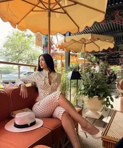Stylish polka dot matching set detail, elegant resort fashion outfit in luxury cafe setting.