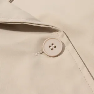 Primer plano detallado de la chaqueta corta beige, destacando la textura de la tela y el botón.