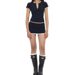 Navy blue knit short sleeve top and mini skirt set with button trim and scalloped collar details.