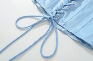 Close-up detail van het lichtblauwe korset met veters, oogjes, bandjes en fijne stiksels.