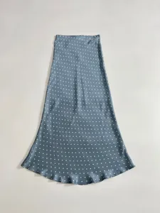 Close-up of blue satin midi skirt featuring elegant white polka dot pattern and smooth fabric texture.