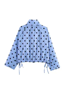 Giacca azzurra a maniche lunghe con pois neri classici, collo alto e coulisse regolabile in basso.