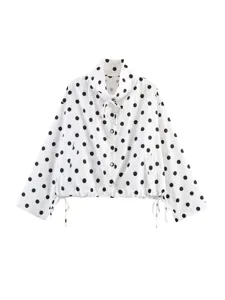 Blusa a maniche lunghe a pois neri e bianchi con collo alto a coulisse e bottoni.