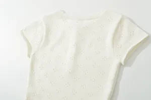 White knitted short sleeve top detail, breathable pointelle knit fabric texture closeup view