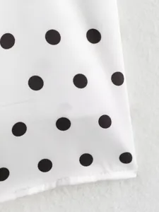 Vista detallada de elegante tela de lunares negros y blancos para top de moda femenina.