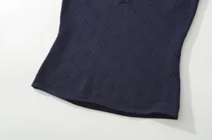 Detailed close-up of dark blue knit top featuring breathable pointelle pattern texture.