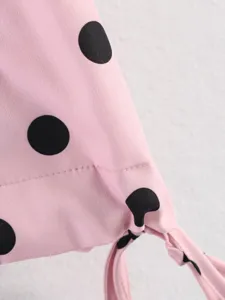 Dettaglio tessuto camicetta a pois neri rosa, stile dolce camicia a maniche lunghe.