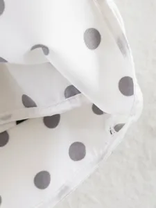 Primer plano detallado del tejido de puntos blancos y grises con costuras finas.