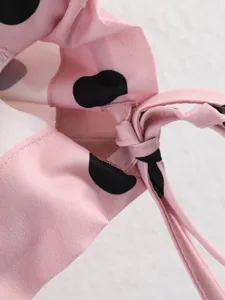 Vista dettagliata della camicia da donna a maniche lunghe con pois grandi in rosa.
