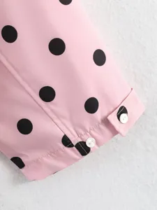 Dettaglio polsino camicia manica lunga rosa con pois neri e bottoni bianchi primo piano.