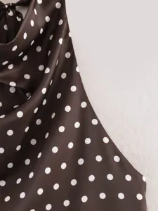 Primer plano detallado del tejido marrón oscuro de lunares con elegante cuello drapeado.