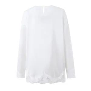 Detailed view of women long sleeve white top with delicate lace trim cuffs and back keyhole.