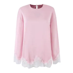 Detailed view of the pink satin long sleeve top with elegant white lace trim at cuffs and hem.