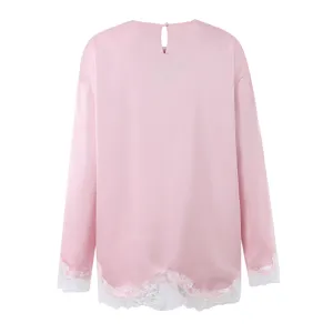 Pink long sleeve top featuring a round neck, back button closure, and delicate white lace trim.