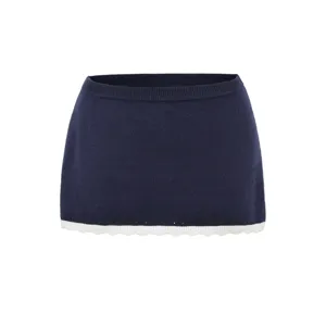 Close-up detail of the dark blue knit skirt showcasing the soft scalloped white hem trim.