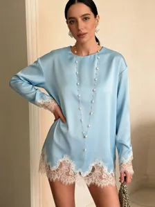 Light blue satin long-sleeve top featuring elegant white lace patchwork at cuffs and asymmetric hem.