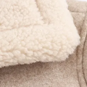 Close-up detail of women's autumn woolen jacket fabric, showing soft sherpa texture and cozy fleece.