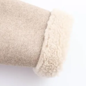 Close-up detail of women winter jacket cuff, khaki wool fabric with cozy white sherpa lining.